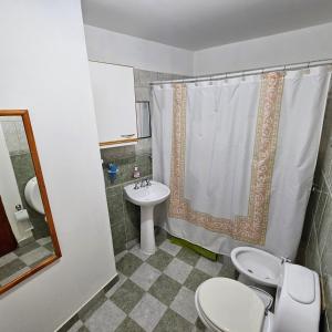 a bathroom with a toilet and a sink and a shower at Casa de familia in Ushuaia