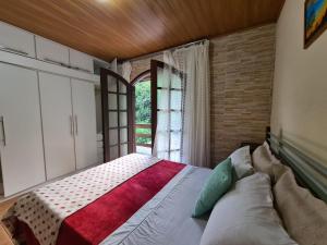 Schlafzimmer mit einem großen Bett und einem Fenster in der Unterkunft Hospedagem El Camino Del Viento in Teresópolis