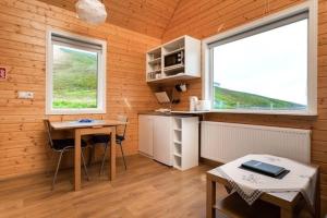 EskifjörðurにあるMjoeyri Travel Holiday Homesのキッチン(テーブル付)、窓2つが備わります。