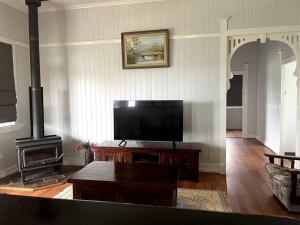 sala de estar con TV de pantalla plana y chimenea en Country charm on acreage, en Kingaroy
