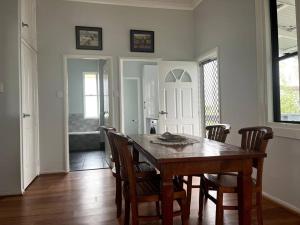 a dining room with a wooden table and chairs at Country charm on acreage in Kingaroy