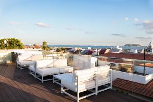 een balkon met witte stoelen en uitzicht op de oceaan bij Hotel San Felipe in Panama-Stad