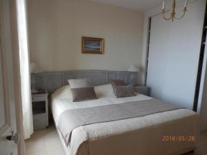 a bedroom with a large bed with two pillows on it at Maison la Belle Plage Asnelles in Asnelles