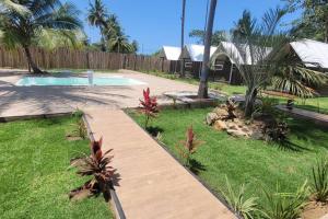 a backyard with a swimming pool and a wooden walkway at Fantastiscos bangalôs em Aracaju in Aracaju