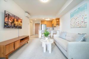 a living room with a couch and a table at Sky Ala Moana 2307 condo in Honolulu