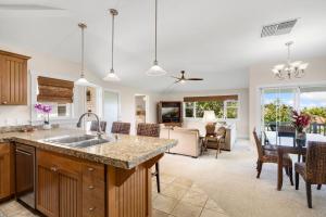 une cuisine avec un évier et un salon dans l'établissement The Plantation at Princeville 222 condo, à Princeville