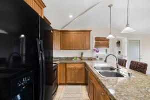 une cuisine avec des armoires en bois et un évier dans l'établissement The Plantation at Princeville 222 condo, à Princeville 34 autres photos