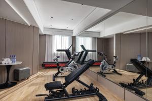 un gimnasio con cintas de correr y elípticas en una habitación en Bali Yating Hotel, en Yiwu