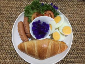 a plate of breakfast food with eggs and a sandwich at BC Summer Beach in Pran Buri