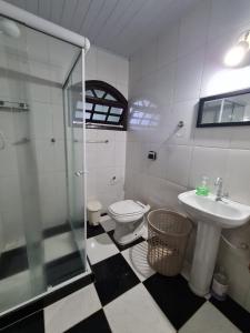 uma casa de banho com um chuveiro, um WC e um lavatório. em Hospedagem El Camino Del Viento em Teresópolis