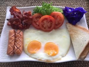 un piatto per la colazione con uova, pomodori e pancetta di BC Summer Beach a Pran Buri