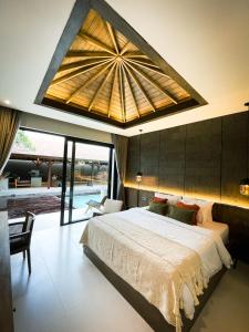 um quarto com uma cama grande e um tecto grande em Luna Ola Villa Berawa em Canggu