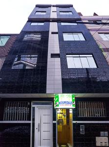 un grand bâtiment noir avec une porte devant lui dans l'établissement Hospedaje Escorpio, à Lima