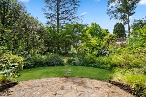 a garden with green grass and trees at Holley House in Leura