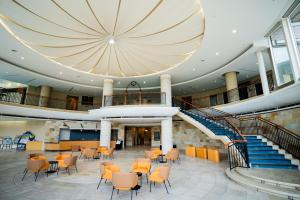 a large lobby with chairs and tables and stairs at Hotel Welview Kagoshima in Kagoshima