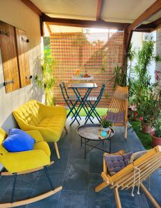 eine Terrasse mit gelben Möbeln sowie einem Tisch und Stühlen in der Unterkunft La Villa Louisia in Matoury