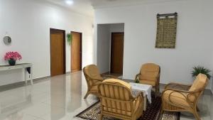 sala de estar con sillas y mesa en Mummy Firdhan Homestay en Rembau