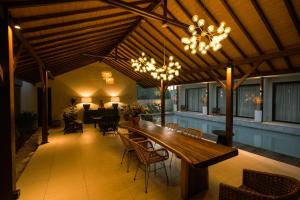 a patio with a large wooden table and chairs at Luna Ola Villa Berawa in Canggu