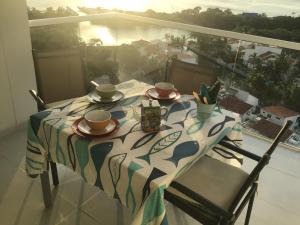 una mesa con platos y tazas en la parte superior de un balcón en areia beach paradaise, en Santa Marta