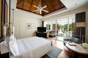 a bedroom with a large white bed and a living room at InterContinental Hua Hin Resort, an IHG Hotel in Hua Hin