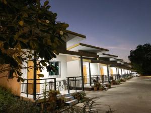 um edifício branco com uma fila de varandas em บ้านชมฟ้า - Bann Chomfah Resort & Cafe 