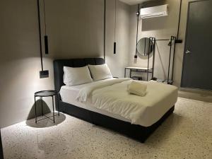 怡保的住宿－M2 Living @ Heart of Ipoh，一间卧室配有一张带白色床单和一盏灯的床。