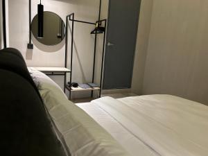 a bedroom with a white bed and a mirror at M2 Living @ Heart of Ipoh in Ipoh