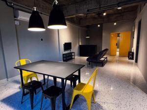 怡保的住宿－M2 Living @ Heart of Ipoh，一间带桌子和黄色椅子的用餐室