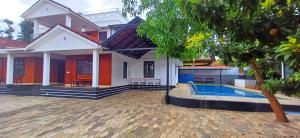 a house with a swimming pool in front of it at Empire Pool Villa in Meenangadi