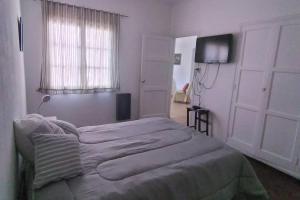 a bedroom with a bed and a window and a television at Roxi Aristides in Mendoza