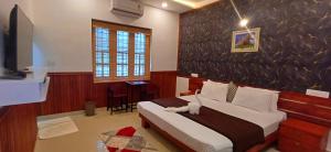 1 dormitorio con 1 cama y TV en Empire Pool Villa, en Meenangadi