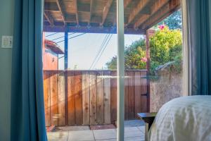 a bedroom with a sliding glass door to a wooden fence at Relaxing Home With SF Bay View in Millbrae