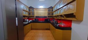 una cocina con encimeras negras y paredes rojas en Empire Pool Villa, en Meenangadi