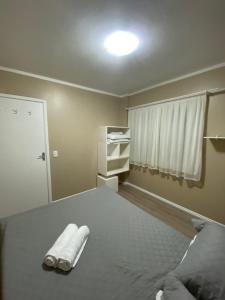 Habitación con 1 cama con toallas en el suelo en Apartamento na rua coberta Gramado, en Gramado