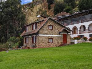 Hotel Refugio Santa Ines في أكيتانيا: منزل من الطوب في حقل بجوار مبنى
