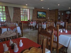 een eetkamer met tafels en stoelen met witte tafelkleden bij Hotel Refugio Santa Ines in Aquitania
