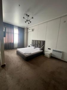 a large bedroom with a large bed and a chandelier at 7Jol Hotel in Khatynkopir