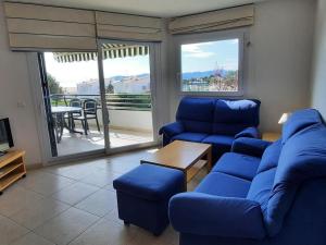uma sala de estar com mobiliário azul e uma varanda em Apartamento Llançà, 3 dormitorios, 6 personas - ES-170-47 em Llançà