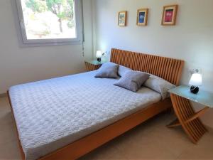 um quarto com uma cama com duas almofadas e uma janela em Apartamento Llançà, 3 dormitorios, 6 personas - ES-170-47 em Llançà