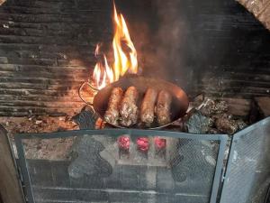 einen Grill mit zwei Würstchen, die darauf kochen in der Unterkunft Gîte Nogent-le-Rotrou, 7 pièces, 12 personnes - FR-1-581-121 in Nogent-le-Rotrou