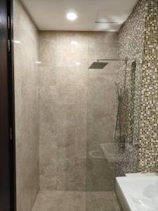 een glazen douche in een badkamer met een wastafel bij Ampang Luxurious Staycation in Kuala Lumpur