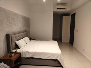 een slaapkamer met een groot bed en een nachtkastje bij Ampang Luxurious Staycation in Kuala Lumpur