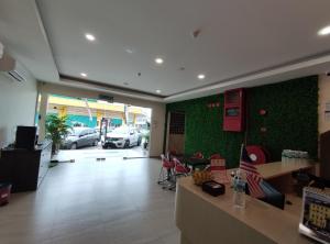 un ristorante con una parete verde con auto parcheggiate in un parcheggio di Mass Hotel a Kampong Kerayong