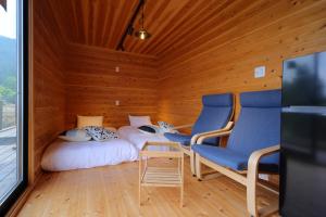 een kamer met 2 bedden en 2 stoelen. bij おそとのてらす　南アルプス in Minami Alps