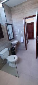 a bathroom with a toilet and a sink and a mirror at Mantarraya in Puerto Baquerizo Moreno +53 photos