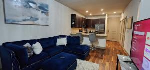 salon z niebieską kanapą i kuchnią w obiekcie Stylish Downtown Retreat w mieście Houston