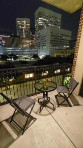 einen Tisch und Stühle auf dem Balkon mit Blick auf die Skyline der Stadt in der Unterkunft Stylish Downtown Retreat in Houston