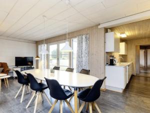 a dining room and kitchen with a table and chairs at 8 person holiday home in V ggerl se in Marielyst