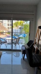 een woonkamer met uitzicht op een patio met een tafel en stoelen bij Manzanillo Depto. ¡buena vibra! in Manzanillo