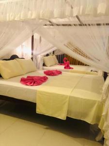 a bedroom with two beds with red roses on them at Coral Palm Villa and Apartment in Unawatuna